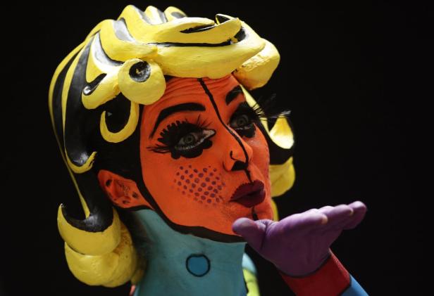 Eine Frau mit Pop-Art-inspiriertem Körperbemalung schickt einen Luftkuss.