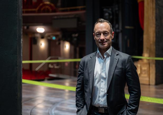 Christian Struppeck steht auf einer Theaterbühne.