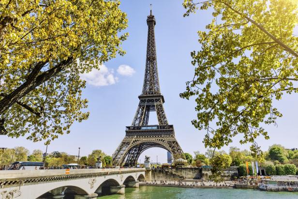 Pariser Eiffelturm im Sommer, grüne Bäume, Sonnenlicht und blauer Himmel