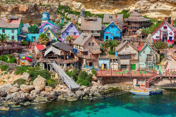 Das Popeye Village in Malta mit seinen bunten Häusern an einer felsigen Küste.