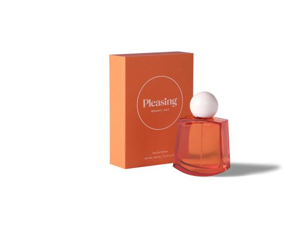 Ein Flakon des Parfüms „Pleasing Bright, Hot“ neben seiner orangefarbenen Verpackung.