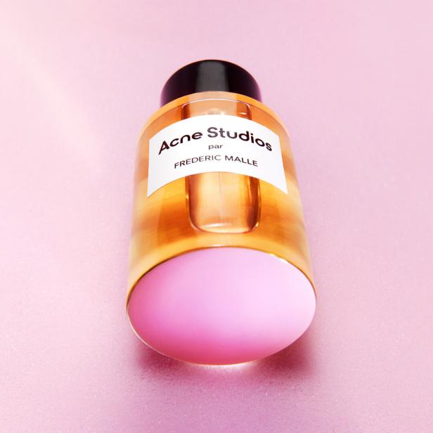 Eine Flasche „Acne Studios par Frederic Malle“ Parfüm vor einem rosa Hintergrund.