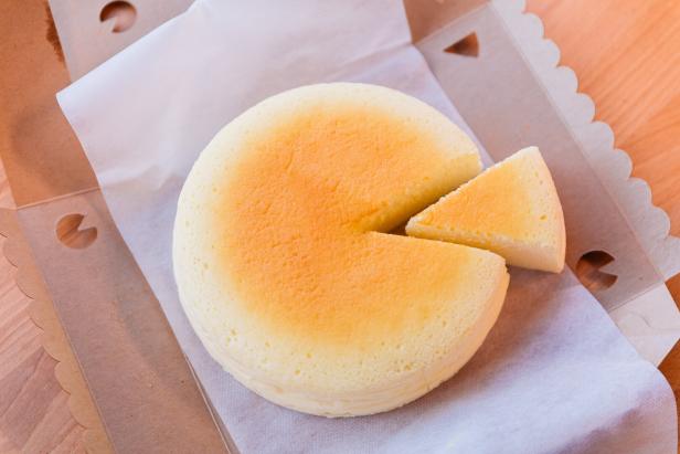 Ein japanischer Käsekuchen mit einem fehlenden Stück in einer Pappschachtel.