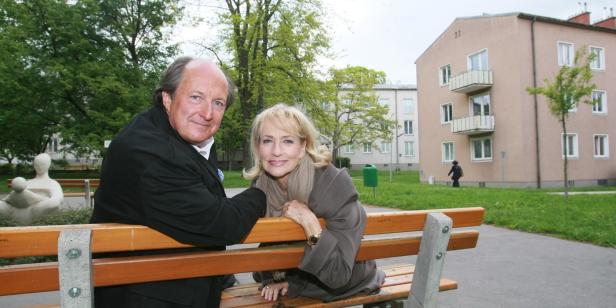 Ein Mann und eine Frau sitzen auf einer Bank in einem Park.