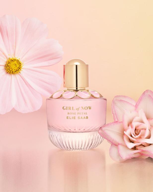 Der rosafarbene Duft „Girl of Now Rose Petal“ von Elie Saab mit Blütenblättern im Hintergrund.