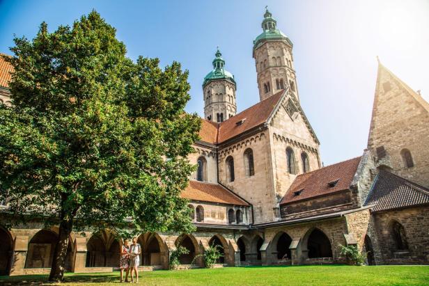 Zwei Frauen im grünen Innenhof einer großen gotischen Kirche.