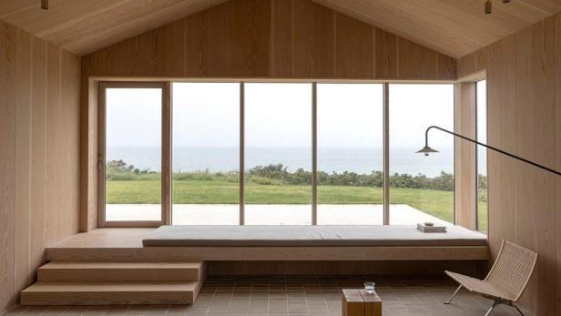 Ein helles, holzvertäfeltes Zimmer mit Blick auf das Meer.