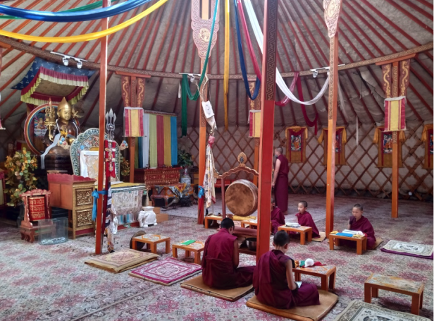 Buddhistische Mönche sitzen in einem traditionellen mongolischen Zelt, einer Jurte.