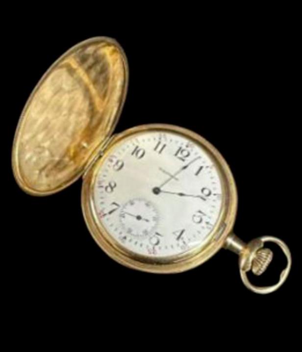 Eine goldene Taschenuhr mit geöffnetem Deckel vor schwarzem Hintergrund.