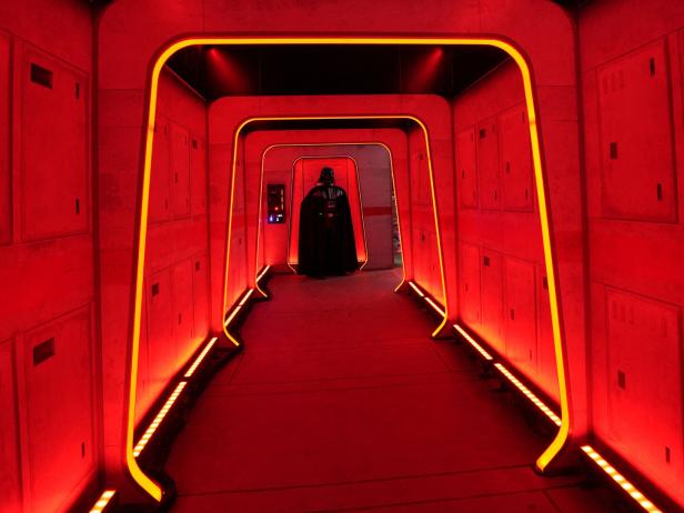 Eine als Darth Vader verkleidete Person steht am Ende eines beleuchteten Flurs während eines „Marsches zum 4. Mai“ in New York City, der ganz im Zeichen des Star Wars-Bösewichts steht.