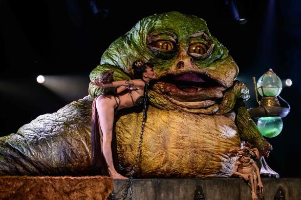 Eine Frau in Ketten und Bikini küsst ein grünes schwabbeliges Monster: Eine Tänzerin tritt in „The Empire Strips Back“ auf, einer burlesken Parodie auf Star Wars im Marie-Bell-Theater im Zentrum von Paris am 22. Oktober 2023.