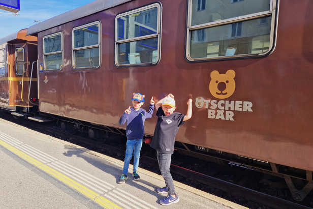Zwei Kinder posieren vor dem Ötscherbär-Zug.