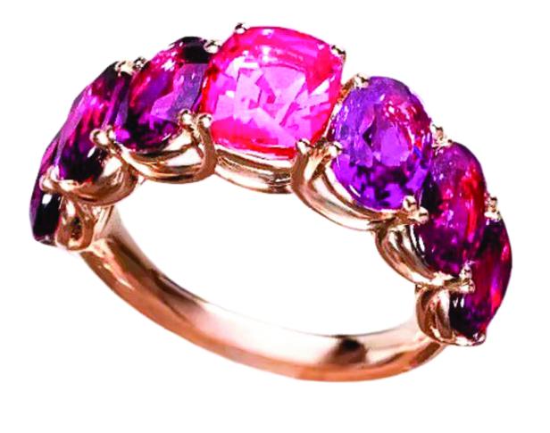 Ein goldener Ring mit pinkfarbenen und violetten Edelsteinen.