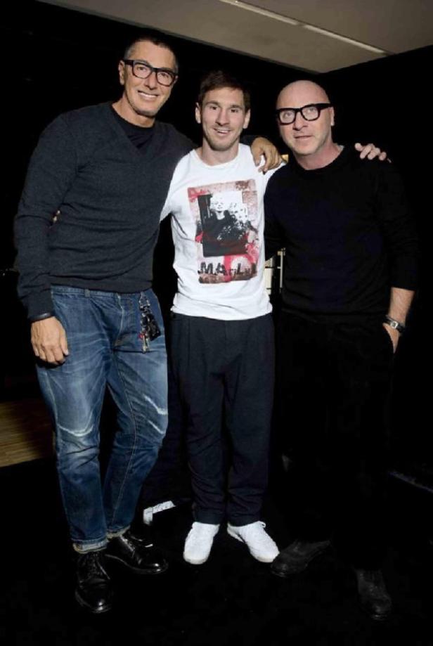 Lionel Messi posiert mit zwei Männern für ein Foto.