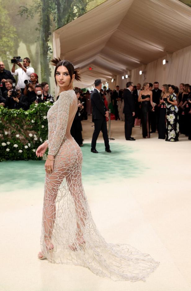 Emily Ratajkowski in einem transparenten, silbernen Kleid auf dem roten Teppich.