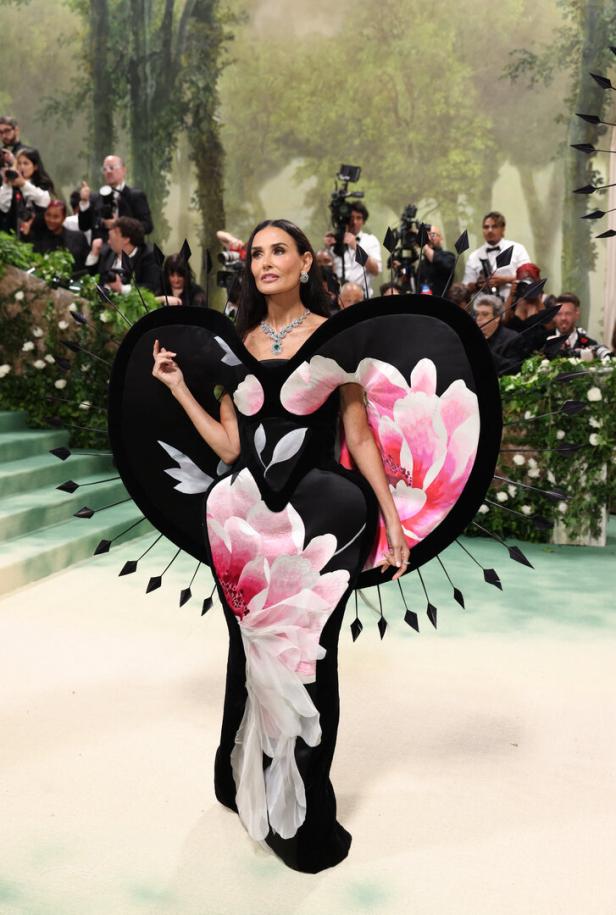 Demi Moore in einem extravaganten, blumengemusterten Kleid auf dem roten Teppich.