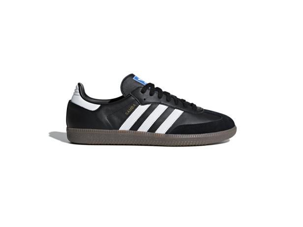 Ein schwarzer Adidas Samba Schuh mit weißen Streifen und brauner Sohle.