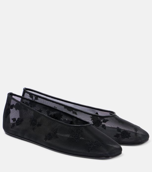 Ein Paar schwarze, transparente Ballerinas mit Blumenmuster stehen auf einem hellen Hintergrund.