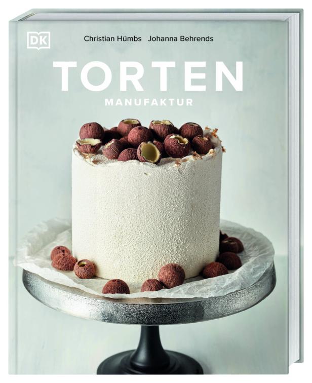 Das Cover des Buches „Torten Manufaktur“ von Christian Hümbs und Johanna Behrends zeigt eine Torte mit Haselnüssen.