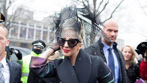 Lady Gaga trägt einen extravaganten Kopfschmuck und eine Sonnenbrille im Schnee.