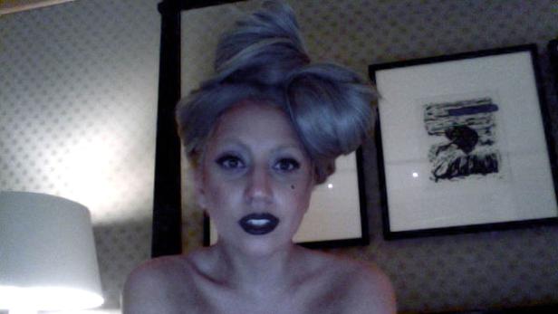 Eine Frau mit grauem Haar und dunklem Lippenstift blickt in die Kamera.