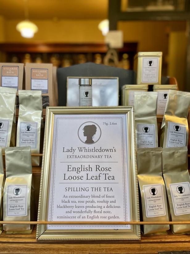 Lady Whistledown's Extraordinary Tea in goldener Verpackung in einem Schaufenster des Teeladens Gillards in Bath, in der Mitte ein Schild mit goldenem Rahmen