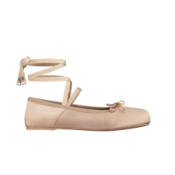 Ein rosafarbener Ballerina-Schuh mit Schleife und Perle, sowie einem Band zum Wickeln um den Knöchel.