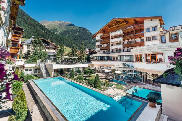 Das Trofana Royal Resort mit Pools und Blick auf die Berge.
