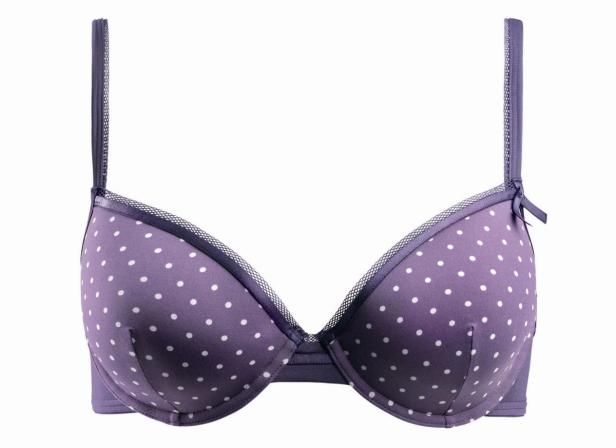 Ein lila BH mit weißen Punkten vor einem weißen Hintergrund.