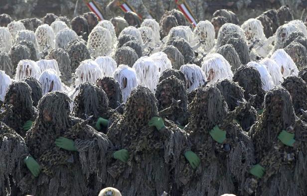 Eine Formation von Soldaten in Ghillie-Anzügen während einer Parade.