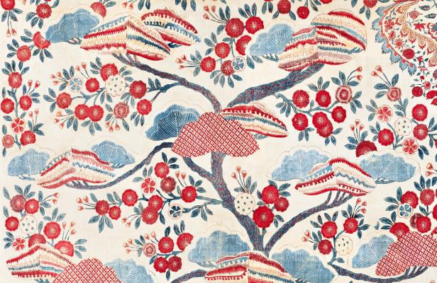 Indienne mit Muster im japanischen Stil. Bäume und Blumen mit roten Blüten und blauen Einsprengseln. Ein mit Beizen- und Reservetechnik eingefärbtes und bemaltes Baumwollgewebe, erste Hälfte 18. Jahrhundert.
