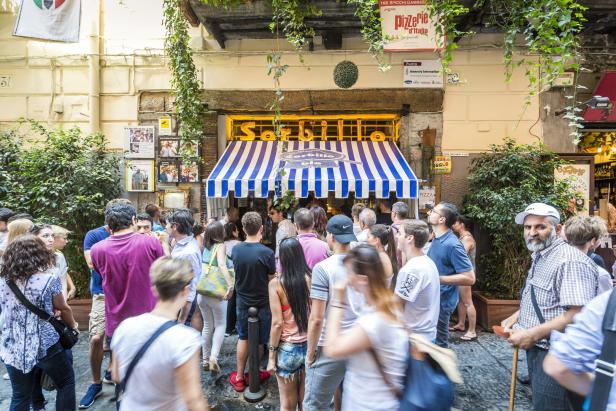 Menschen stehen vor dem Eingang der Pizzeria „Sorbillo“ in Neapel Schlange.