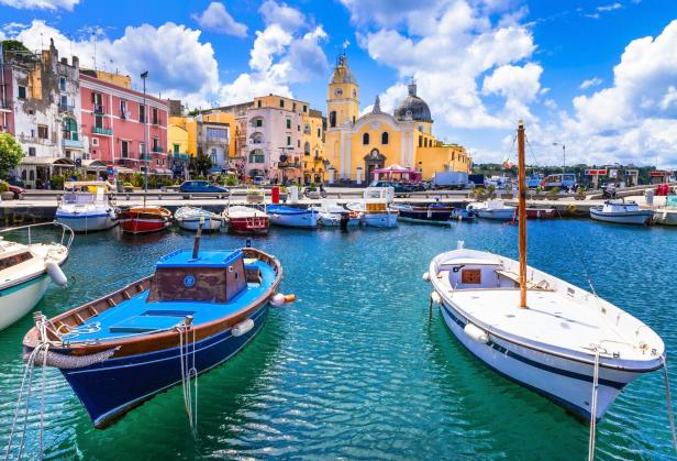 Bunte Häuser und Boote im Hafen von Procida, Italien.