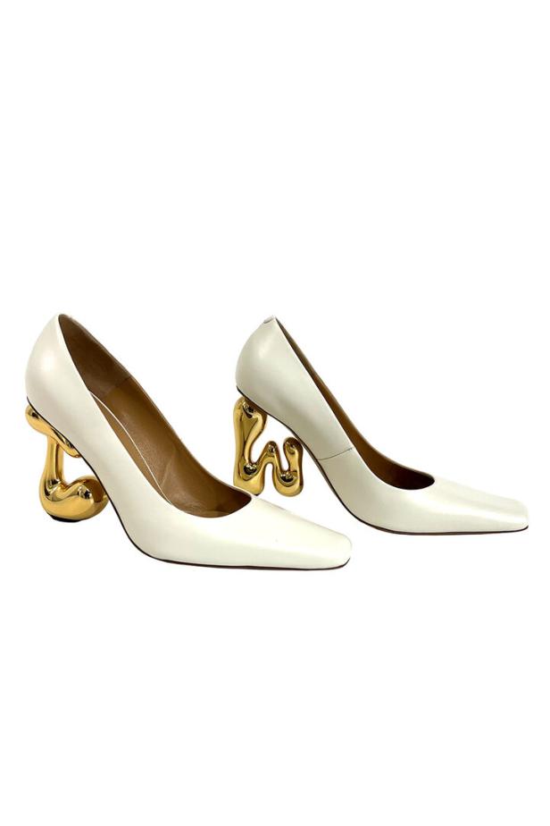 Ein Paar weiße Pumps mit goldenen, skulpturalen Absätzen.