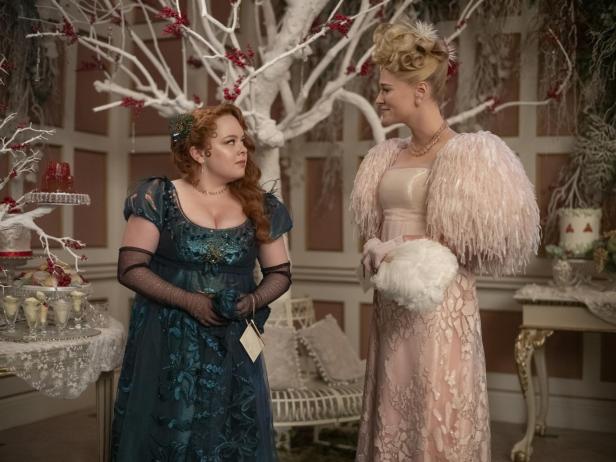 Penelope Featherington und Eloise Bridgerton in eleganten Ballkleidern bei einer Gesellschaft in „Bridgerton“.