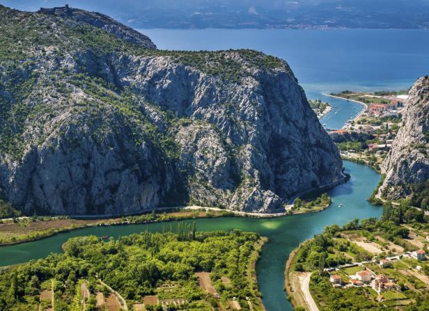 Der Fluss Cetina schlängelt sich durch eine grüne Landschaft in Kroatien.