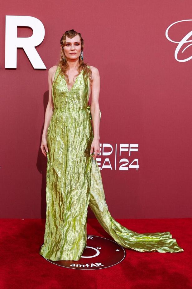 Diane Kruger in einem grünen Kleid auf dem roten Teppich der amfAR Gala 2024.