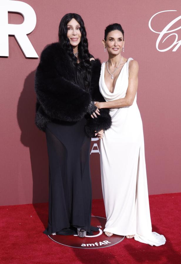 Cher und Demi Moore posieren auf einem roten Teppich.
