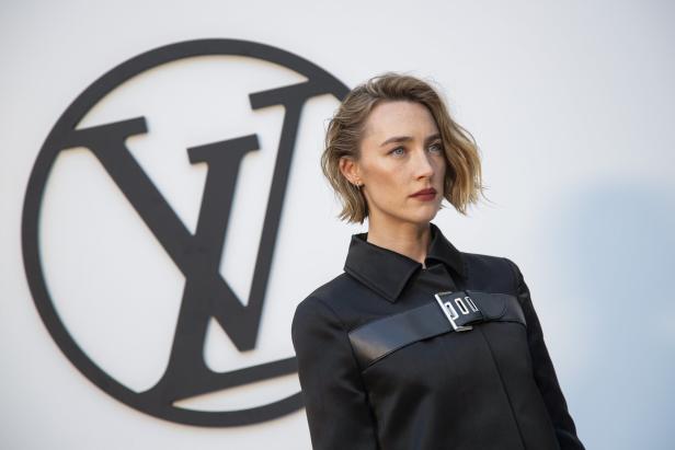 Saoirse Ronan posiert vor einem Louis-Vuitton-Logo.