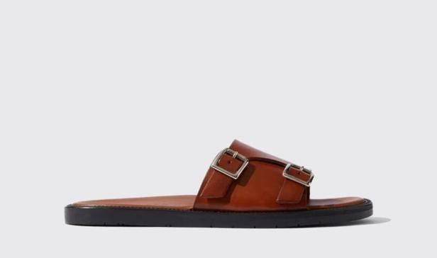 Ein brauner Ledersandalen-Slipper mit zwei silbernen Schnallen.