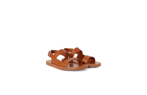 Ein Paar hellbraune Ledersandalen mit Riemchen stehen auf einem weißen Hintergrund.