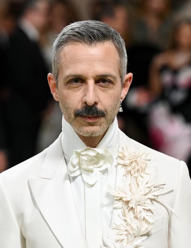Jeremy Strong in einem weißen Anzug mit floralen Akzenten.