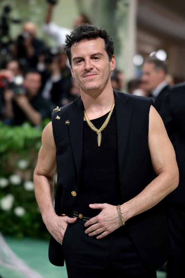 Andrew Scott trägt ein ärmelloses Jackett und eine goldene Halskette auf dem roten Teppich.