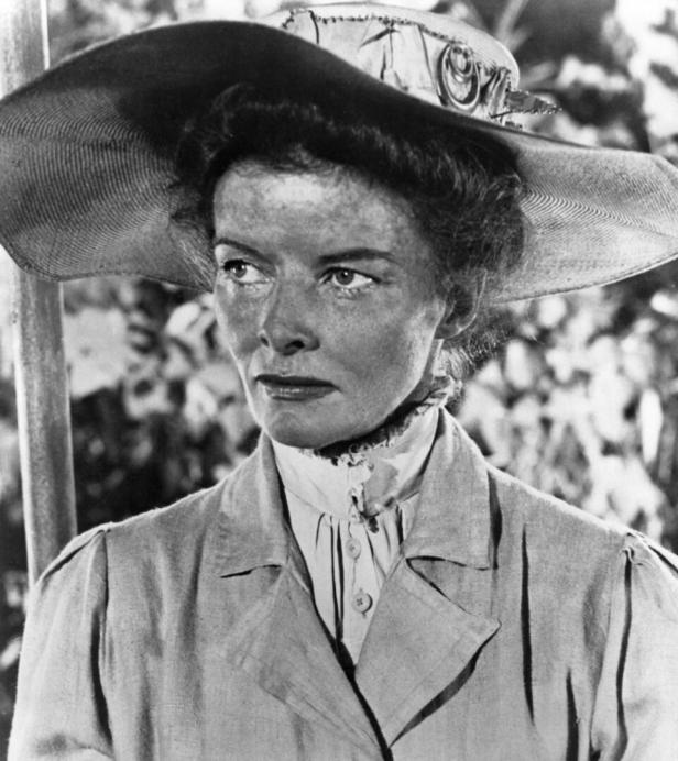Katharine Hepburn mit einem großen Hut in einer Filmszene.