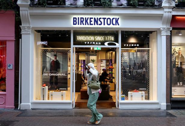Eine Person fotografiert vor einem Birkenstock-Geschäft.