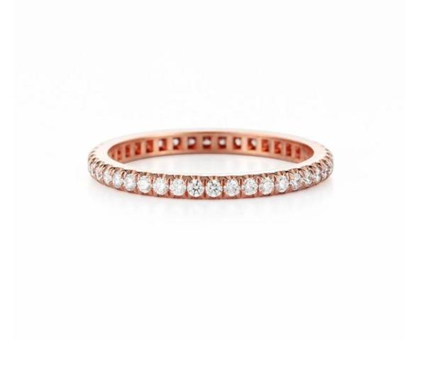 Ein schmaler, roségoldener Ring ist mit kleinen Diamanten besetzt.