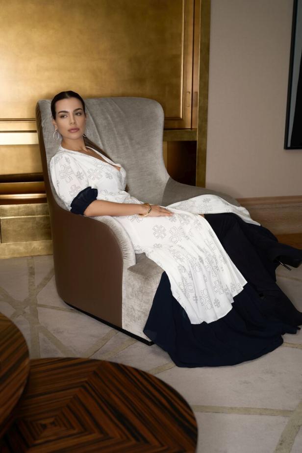 Model Nadine Mirada in Stoffe, inspiriert von einer Hotelfassade, gehüllt