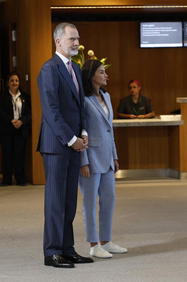 König Felipe und Königin Letizia von Spanien stehen zusammen in einem Gebäude.