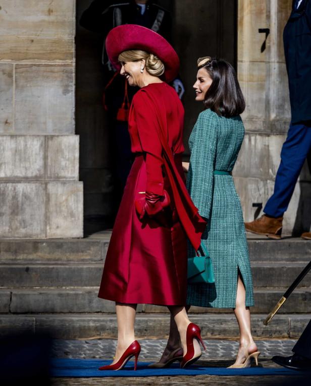 Königin Máxima und Königin Letizia gehen zusammen eine Treppe hinauf.