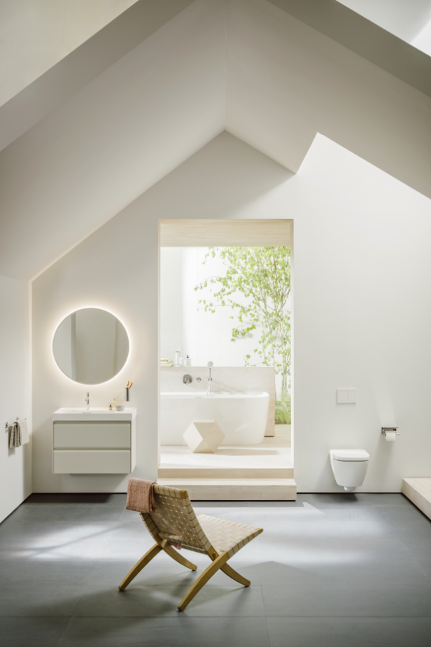 Ein modernes Badezimmer mit freistehender Badewanne und einem Stuhl im Vordergrund.